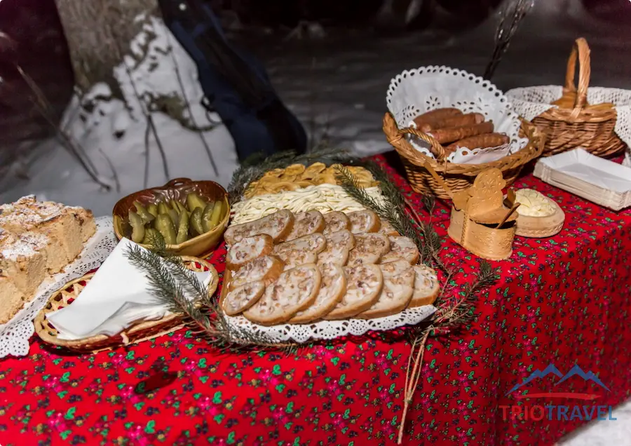 Sleigh ride participants with torches in a mountain scenery