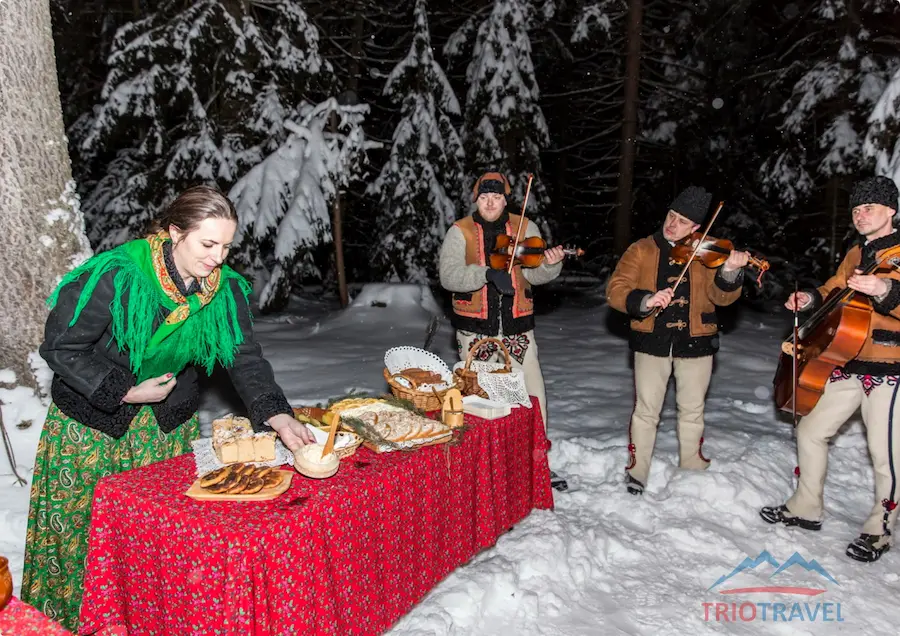 Sleigh ride participants with torches in a mountain scenery