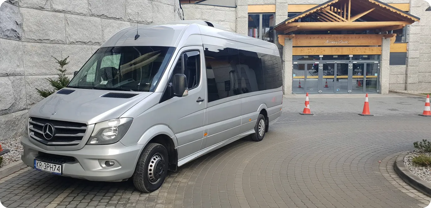 Bus in a parking lot with a thermal spa in the background
